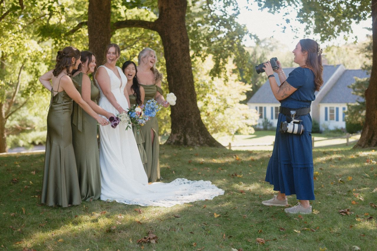 wedding photographer taking photos of bridesmaids laughing